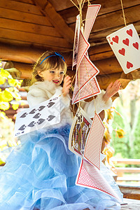 一个美丽的小女孩 玩耍和跳舞 用大牌在桌上打牌的游戏时间想像力创造力魔法仙境艺术概念故事裙子冒险背景图片