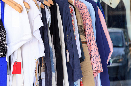 妇女衣着的多彩织物架棉布架子衣架零售裙子女装销售架服装店织物背景图片