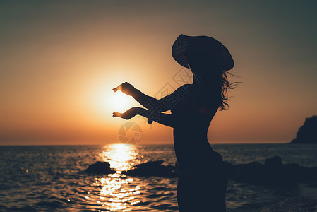 日落时值日光耀太阳的年轻女性背景