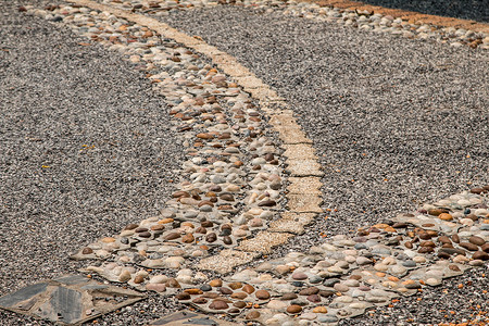 卵石路路径由石头组成白色建筑马赛克灰色地面卵石材料鹅卵石岩石黑色背景