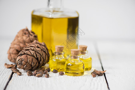 雪松坚果油玻璃营养坚果松属芳香瓶子木头松树饮食疗法背景