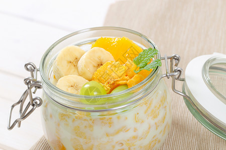 带奶粉和新鲜果实的玉米薄片水果橙子黄色牛奶食物玻璃谷物早餐香蕉背景图片