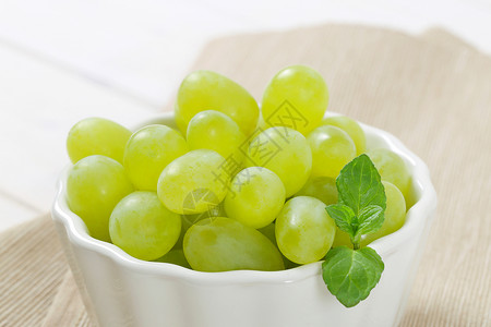 白葡萄的碗绿色藤蔓水果白色甜点褐色小吃餐垫折叠浆果背景图片