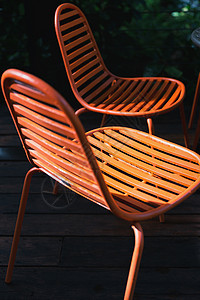 黑幕中的橙色椅子金属近焦家具阳光花园阴影背景图片