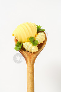 勺子上的黄油卷曲心结传播食品厨房用具炊具高架卷发食物香菜奶制品背景图片
