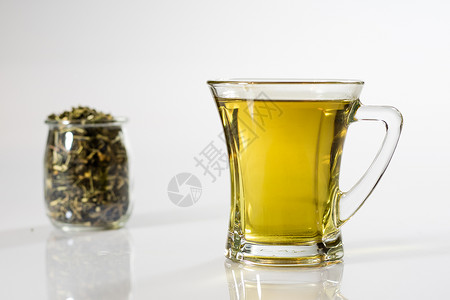 白色背景的茶杯中的茶 绿色或水果茶杯子液体橙子餐具茶点食物盘子早餐药品工作室背景图片