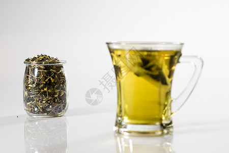 白色背景的茶杯中的茶 绿色或水果茶草本植物食物餐具液体药品橙子早餐盘子饮料杯子背景图片