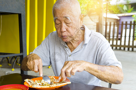 高龄亚洲人退休桌子老年男性男人享受早餐食物背景图片