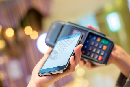 手机识别使用移动电话支付费用的妇女交易购物女孩男人账单手机女士男性同步方法背景