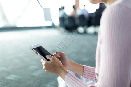 会议室内使用手机的妇女背景图片