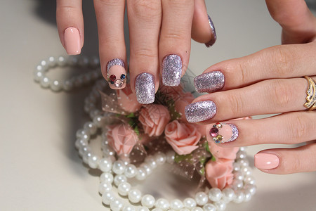 配石头的精美修指甲设计美甲沙龙女性手指修脚紫色白色艺术女士背景图片