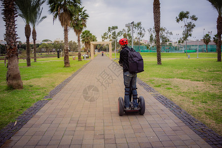 赛格希夫男人在公园的Segway上骑马发动机司机运动娱乐机器车辆乐趣观光旅游运输车背景