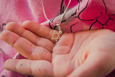 六福珠宝一个女孩手上戴着大卫之星的领带信仰珠宝金属奖章装饰品星星女孩宗教项链友谊背景