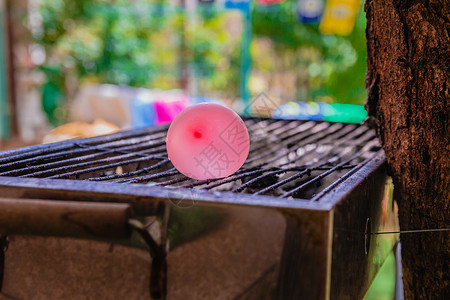 热烤炉上装满了水的水的气球炙烤橙子金属乐趣喜悦公园橡皮玩具实验花园背景图片