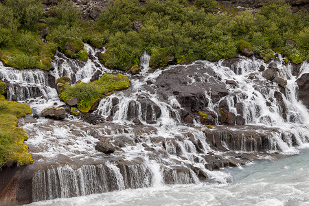 瀑布冰岛流动蓝色溪流绿色跑步瀑布火山荒野背景图片