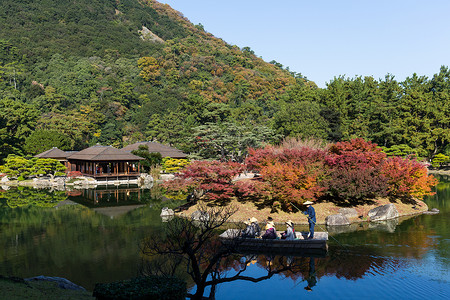 水瓜传统的日本里瓜林花园木头树叶行人树木蓝色植物学花园水池天桥房子背景