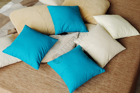 蓝色弹床床铺上丰富多彩的枕头温暖和舒适棉布褐色蓝色白色背景