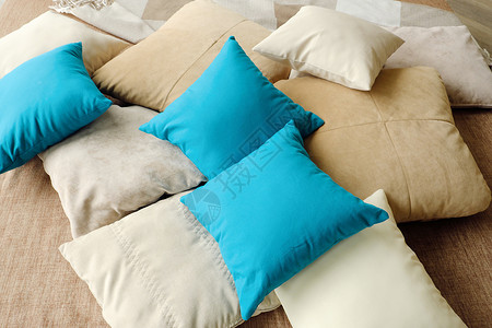 蓝色枕头床铺上丰富多彩的枕头温暖和舒适褐色蓝色白色棉布背景