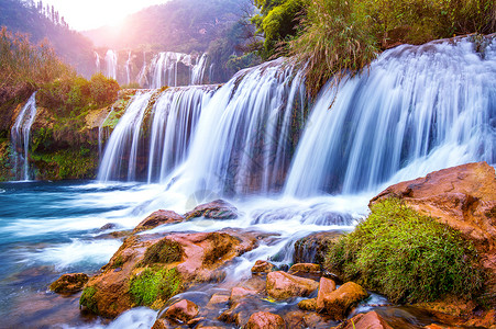 龙归寨瀑布中国卢平的久龙瀑布流动公园世界石头旅行假期支撑天空蓝色旅游背景