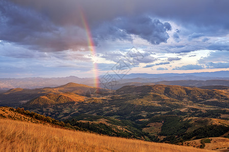 彩虹云素材山区风景彩虹色彩季节旅行草地岩石太阳爬坡阳光金子树木背景