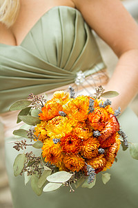 由伴娘持有的橙色布花背景图片