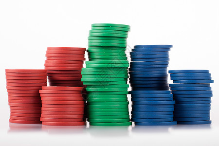 斯塔克斯的廉价塑料粉片芯片绿色投注扑克白色蓝色红色反射筹码背景图片