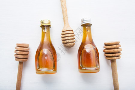白木本底的木制和小蜂蜜瓶高清图片