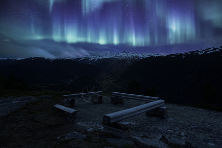 极光区在挪威山丘本海宁和极光的一席长椅上背景