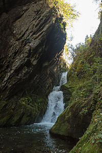 在森林中隐藏的小瀑布 在岩石的裂缝里石头溪流森林荒野旅游叶子秘密天堂树木丛林图片