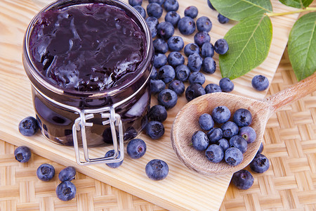 蓝莓果果酱枝条叶子水果勺子盘子陶瓷沙漠制品厨房绿色背景图片