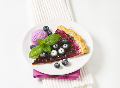 火焰冰淇淋带冰淇淋的蓝莓薄饼餐垫美食食物甜点紫色蛋糕奶油餐巾水果白色背景