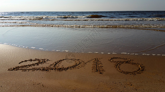 在沙滩上绘制 2018 位数字 在 beac 中绘制的数字蓝色海浪支撑学习字体绘画海洋海滨打字稿教育背景图片