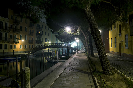在威尼斯的夜晚游客城市街道小夜灯假期戏剧性历史性旅游建筑天空背景图片