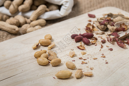 花生碎裂开坚果水果麻布营养木头种子食物解雇棕色织物背景图片