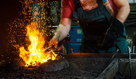 锤子投掷工作中的铁匠工艺罢工工匠职业火焰煤炭手臂齿轮橙子烧伤背景