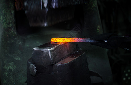 锤子投掷工作中的铁匠行动橙子工匠男人生产煤炭齿轮工人锤子火焰背景
