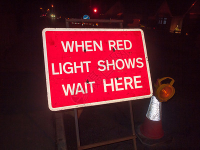 当红灯亮着等他的时候 夜路的红色建筑标志高清图片