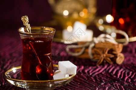 传统玻璃中的土耳其茶勺子八角水平红色饮料飞碟液体茶壶火鸡金属背景图片