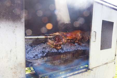 传统的巴肯菜  一整只猪在野火上烤焦了动物小猪煤炭拉刀烹饪食物美食烧烤餐厅木炭背景