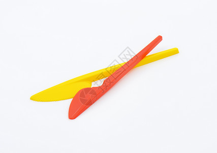 可处置的彩色塑料夹黄色刀具餐具红色背景图片