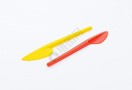 可处置的彩色塑料夹餐具红色黄色刀具背景图片