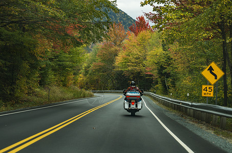 白色山上的公路上驾摩托车的机动车头盔摩托车手骑士友谊国家冒险自行车驾驶自由旅行背景图片