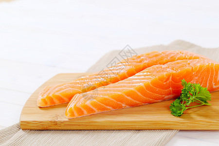 生鲑鱼片餐垫食物折叠橙子牛扒褐色砧板鱼片背景图片