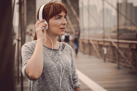 女性在锻炼后休息运动城市跑步音乐女孩训练运动员耳机背景图片