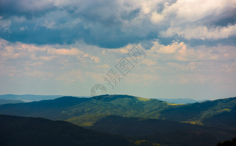 雨季的山地风貌气氛多云下雨编队爬坡驼峰场景海拔风景土地背景图片