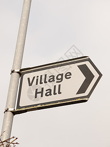 白色和黑色的村内大厅标志前街金属场景远足指针天空指示牌外观英语房屋地点背景图片