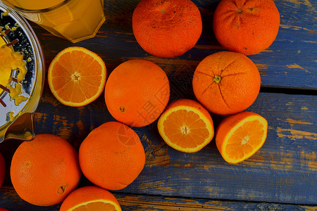 平面素材器橘子 橙子 橙汁和蓝木本底的手工柑橘饼 橙子切成两半 顶端视图 平面设计早餐水果厨房铰刀玻璃橙色木板吸管节食榨汁机背景
