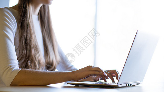 在大窗口前的笔记本电脑键盘上贴近女性手打字图像桌子职场商业铅笔购物女孩学生技术窗户衬衫背景图片