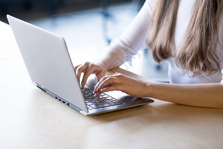 在大窗口前的笔记本电脑键盘上贴近女性手打字图像工作学生人士办公室女孩商业商务成人职场购物背景图片