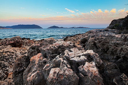日落过火山岩石海岸线的风景背景